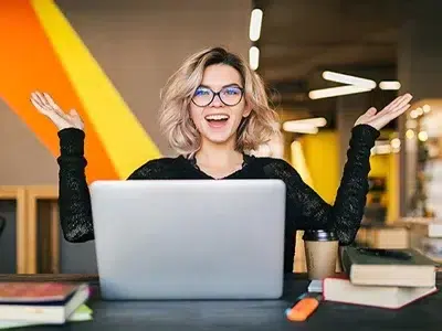 Mulher feliz em frente a um computador, assistir a uma formação à distância