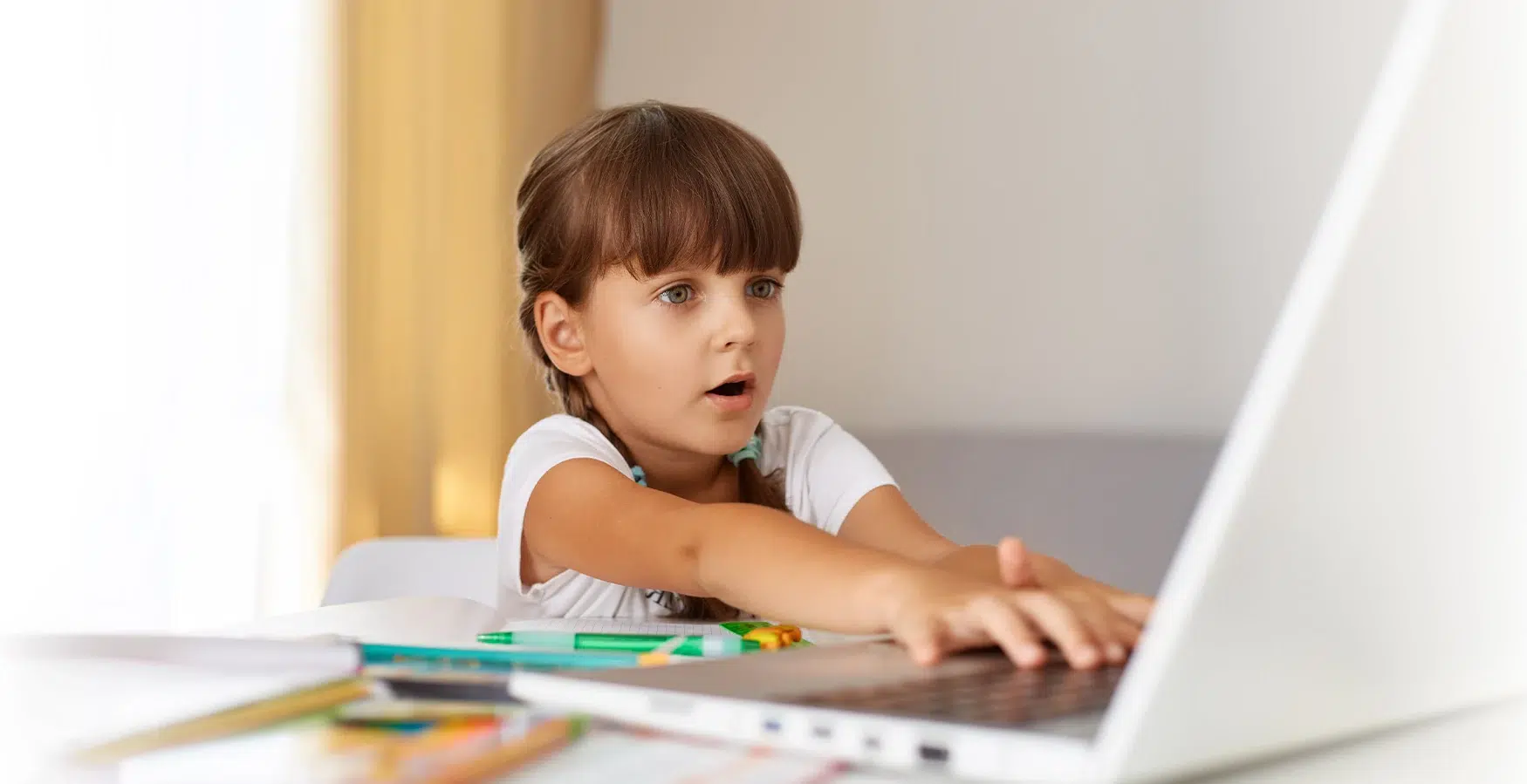 Criança a mexer no computador, no âmbito do Curso de Necessidades Educativas Especiais – Autismo e Síndrome de Asperger 