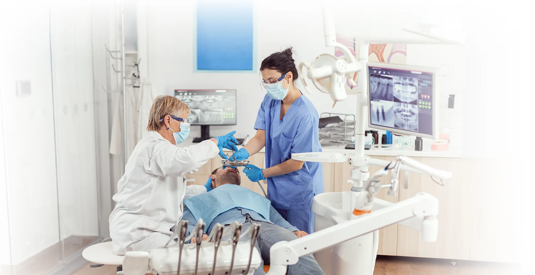 Dentista e assistente de clínica dentária a executarem uma cirurgia oral, após o Curso de Preparação e Apoio em Cirurgia Oral.
