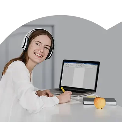 Rapariga de fones e de computador ligado a utilizar o Word, no âmbito do Curso Microsoft Word - Básico